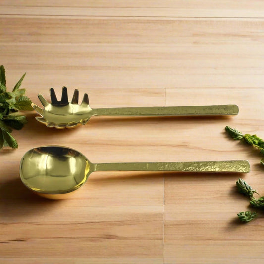 gold pasta server on a wooden table