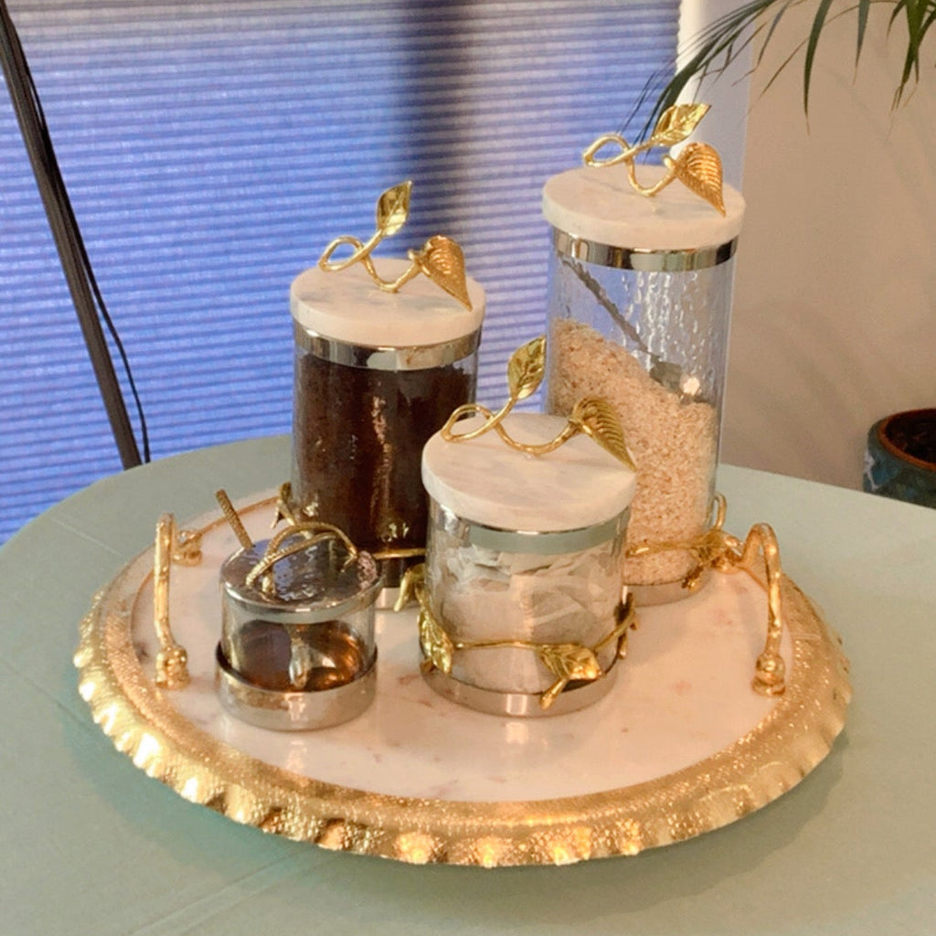 Round Marble Tray with Ruffle Gold Edge and handles displaying jars for serving or decoration.